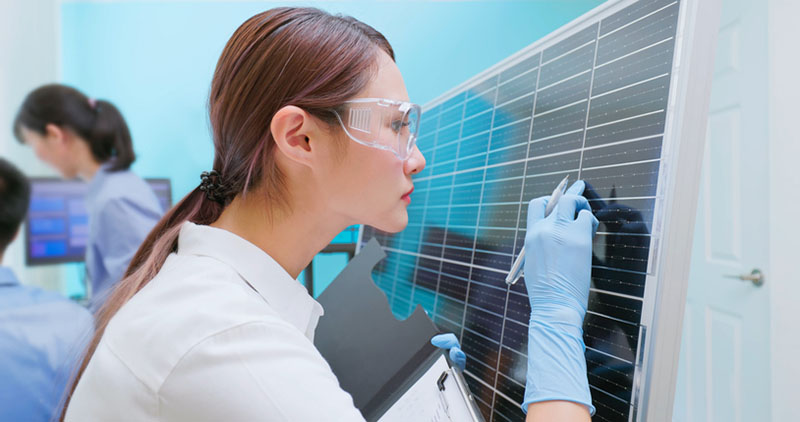 a woman inspects a panel in solar due diligence to ensure safety and quality of the product.